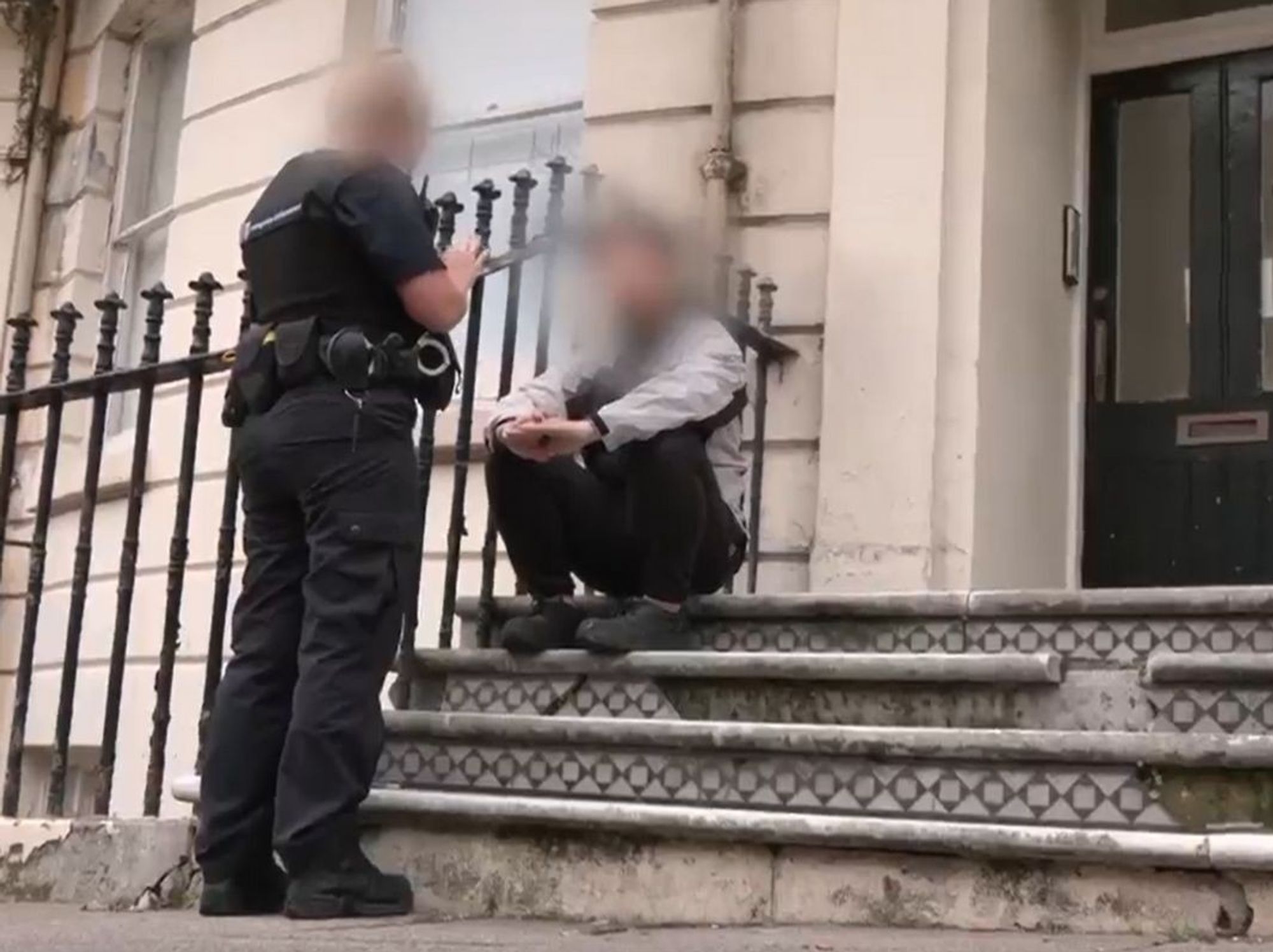 A law enforcement officer addresses a migrant found to have been working illegally