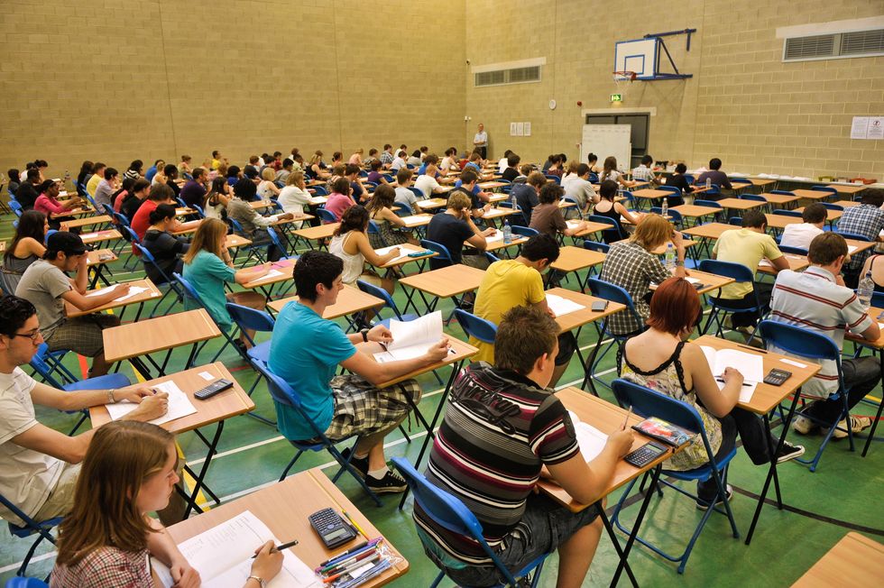 A-level students sit an A-level maths exam inside a sports hall