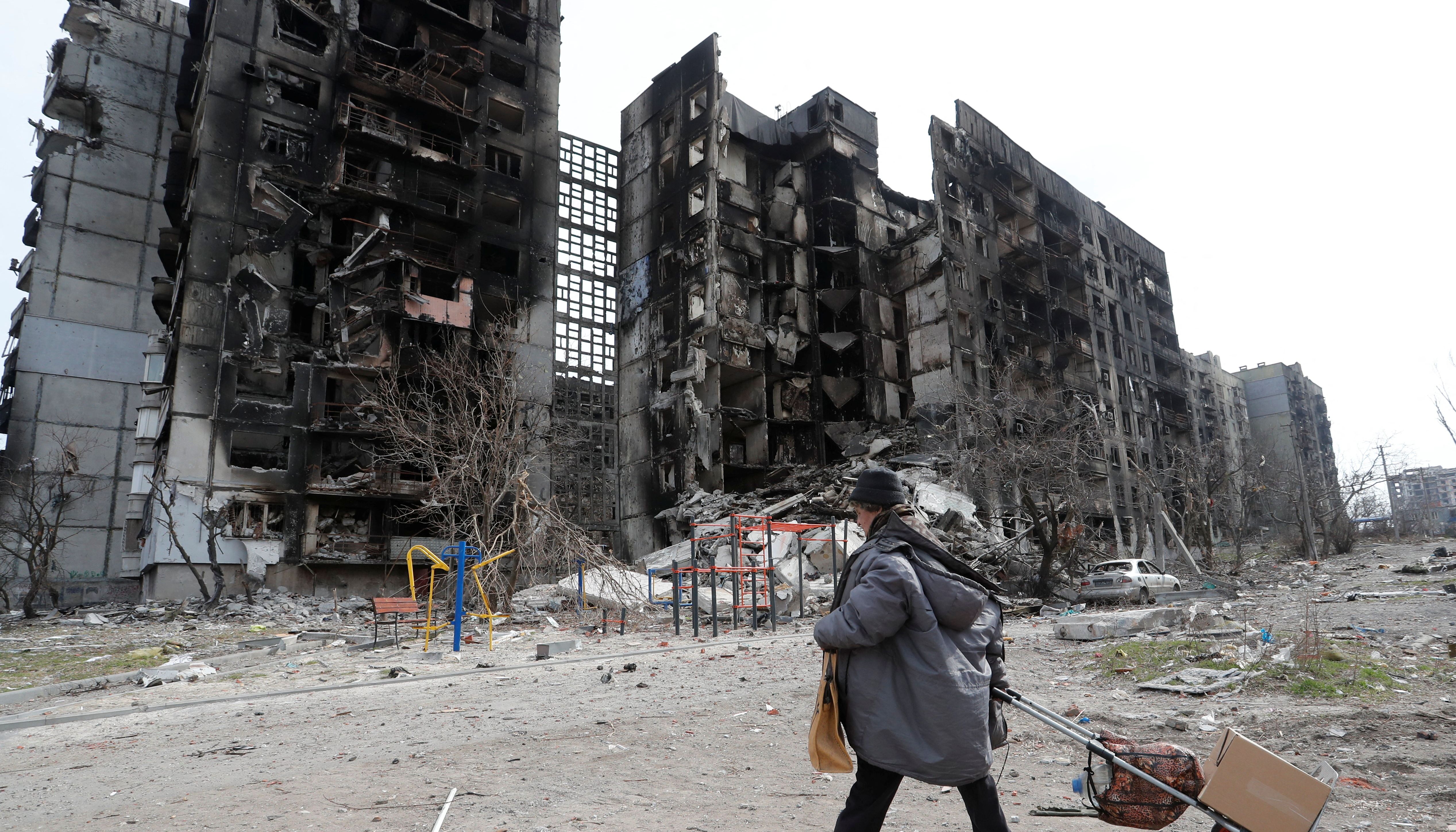 A local resident walks near an apartment building destroyed during Ukraine-Russia conflict in the southern port city of Mariupol, Ukraine April 3, 2022. REUTERS/Alexander Ermochenko