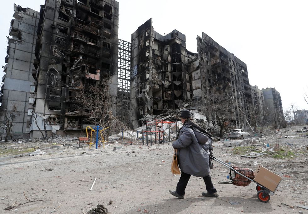 A local resident walks near an apartment building destroyed during Ukraine-Russia conflict in the southern port city of Mariupol, Ukraine April 3, 2022. REUTERS/Alexander Ermochenko