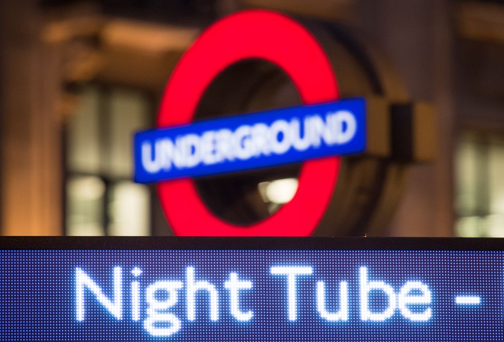 A London Underground roundel alongside an advert for the night tube at Oxford Circus underground station, in London