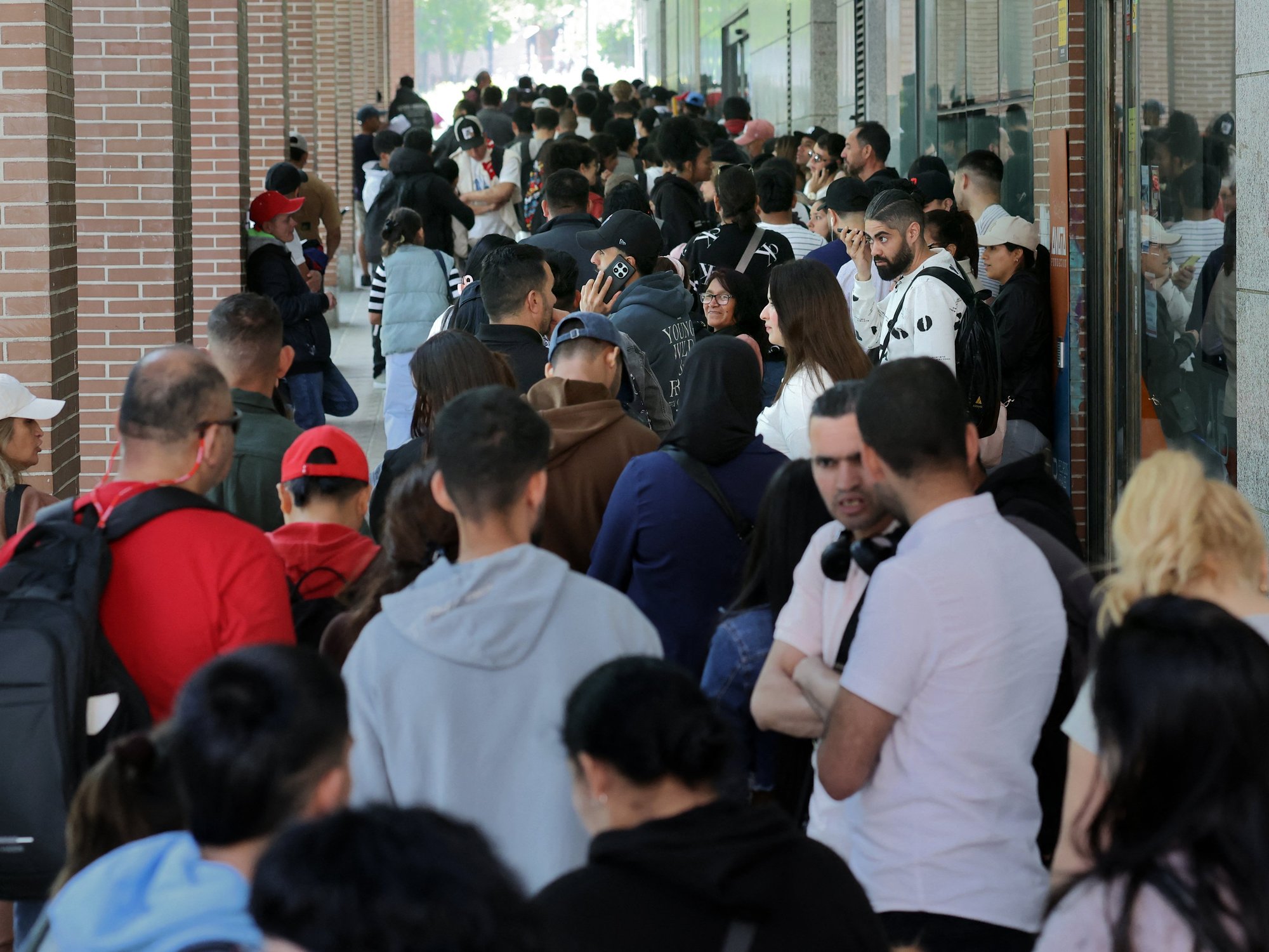 A long queue of migrants outside the Spanish Commission For Refugee Aid building