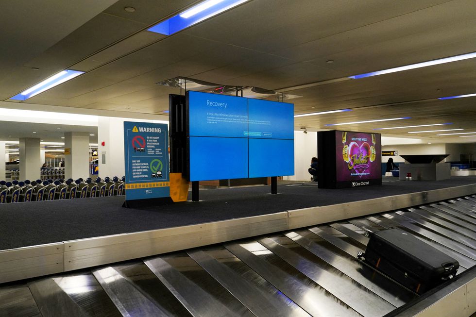 a luggage conveyor belt with bags going past and a BSOD error message