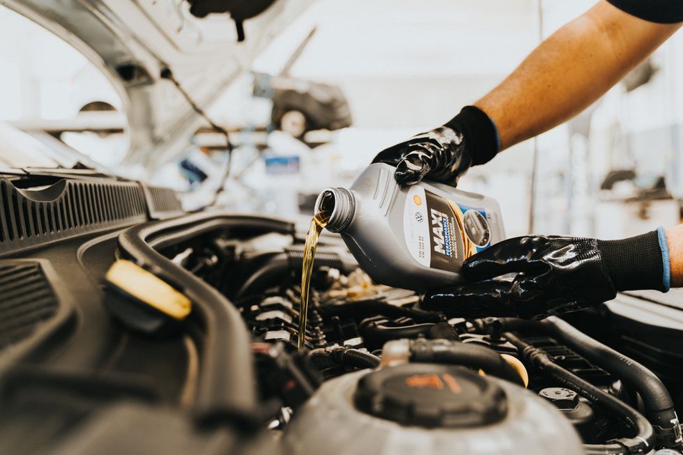 A man adding engine oil to his car