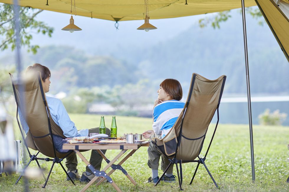 A man and a woman sitting at a campsite