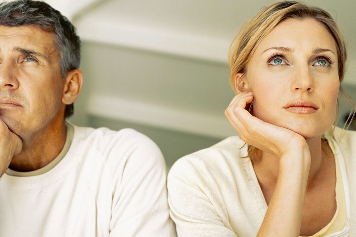 A man and woman looking pensive next to each other 