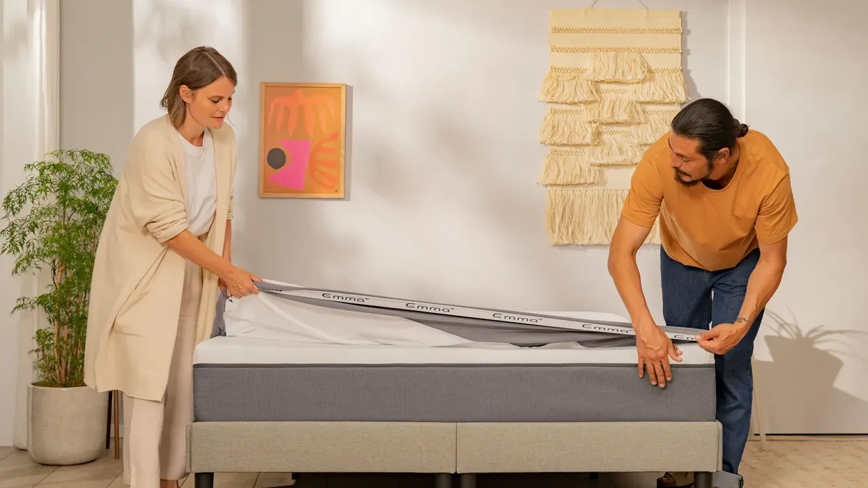 A man and woman make the bed
