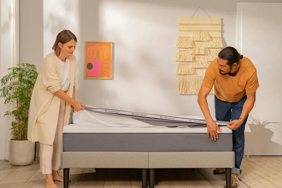A man and woman make the bed