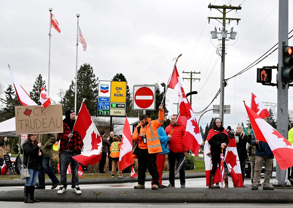 A man bows his head as a prayer is offered over a loud speaker as supporters continue to protest coronavirus disease (COVID-19) vaccine mandates near the border in Surrey, Canada.