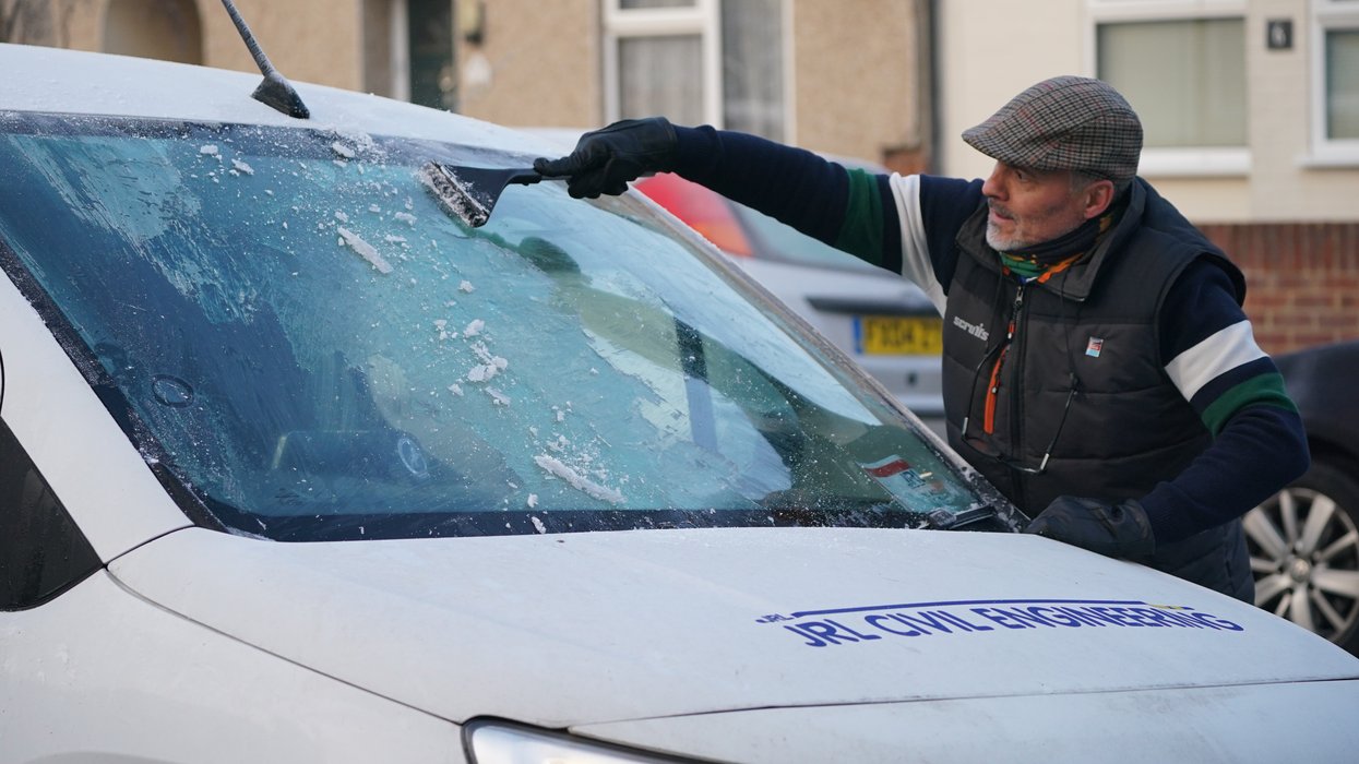 A man clearing windscreen frost