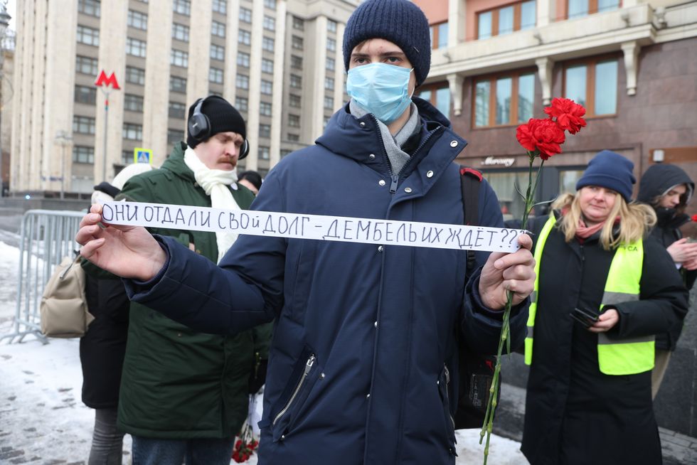 A man comes together with members of the women's movement "Way home" to lay flowers to the Unknown Soldier's Tomb