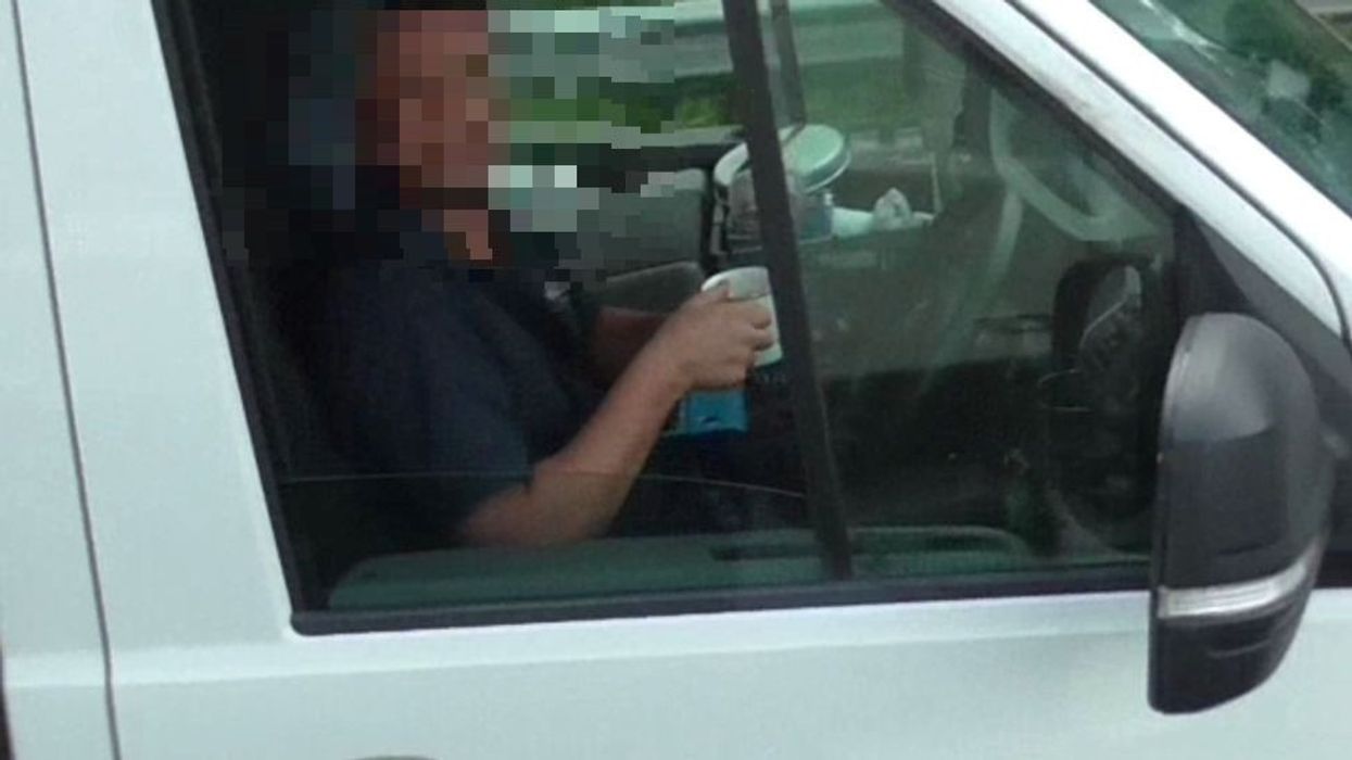 A man drinking tea when driving