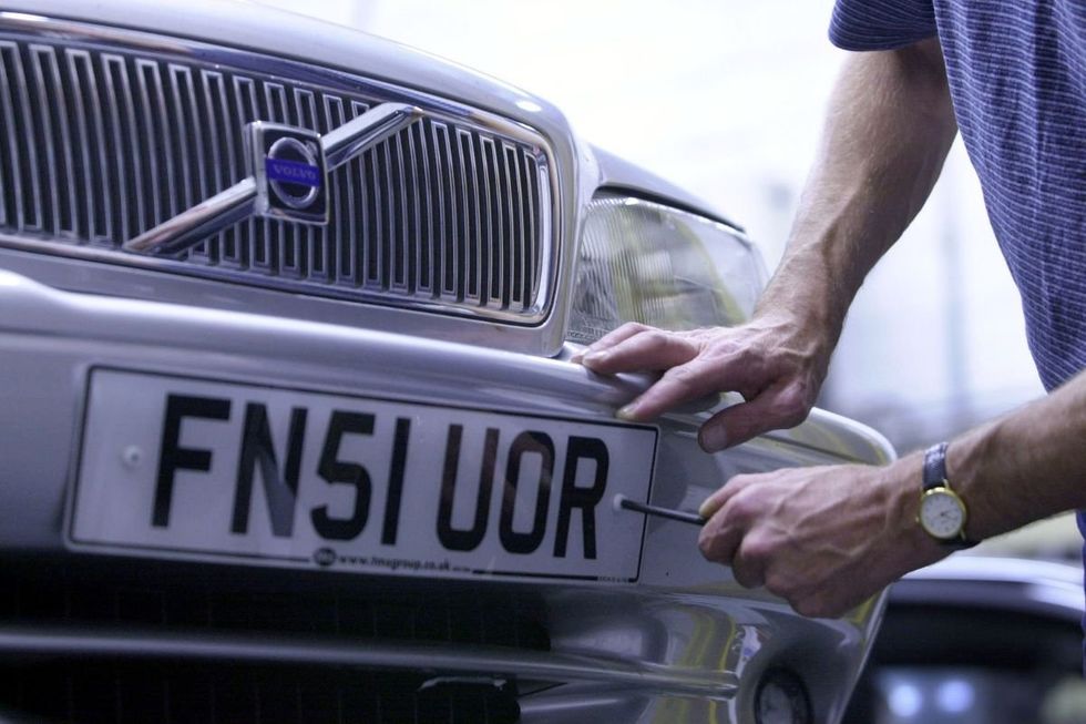 A man fixing a number plate
