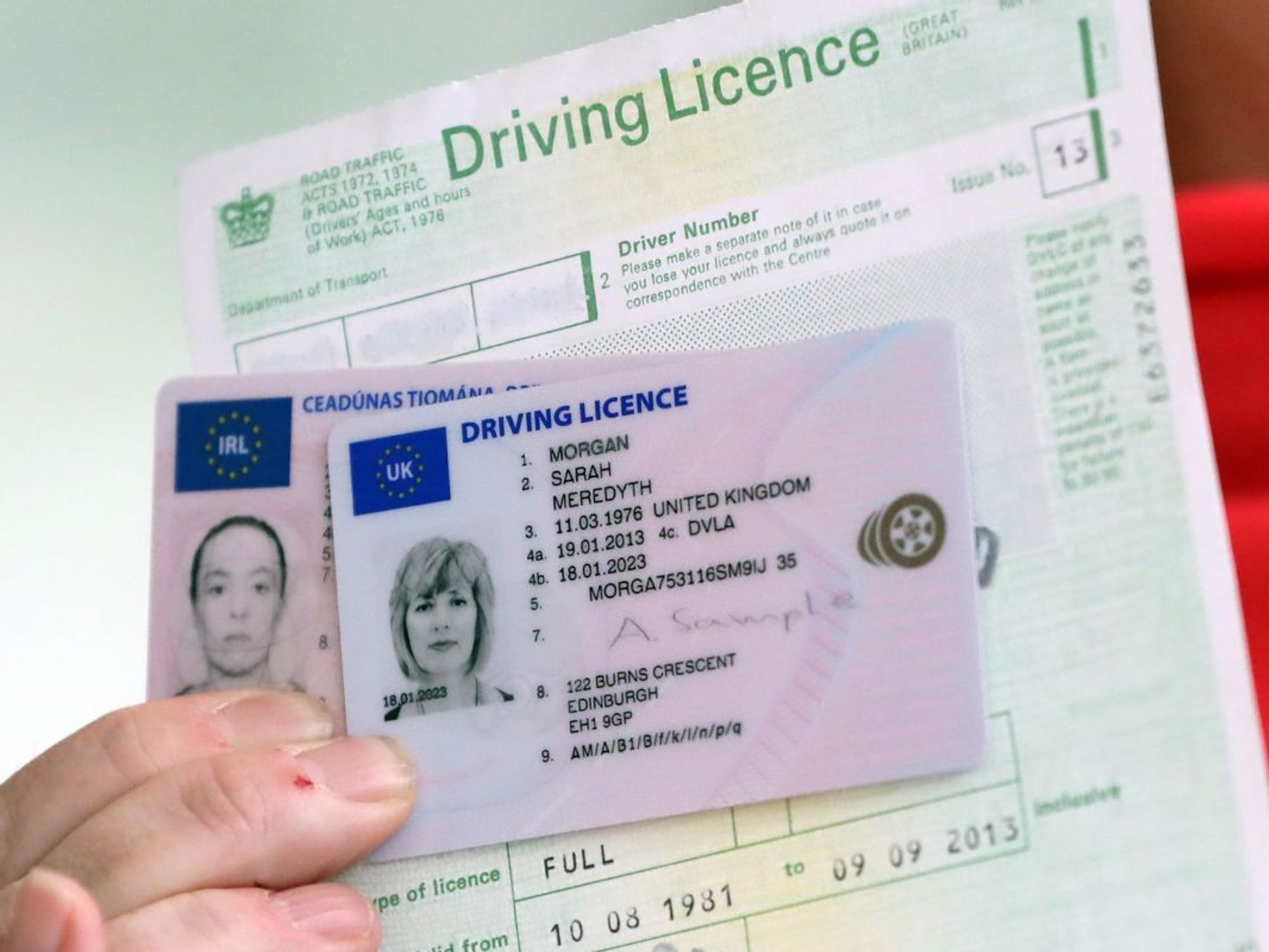 A man holding up a driving licence and licence form