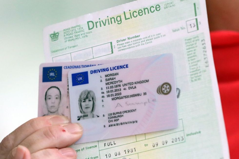 A man holding up a driving licence and licence form