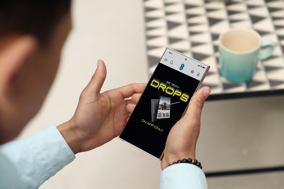 a man holds a galaxy s25 ultra phone in his hands and looks at the EE Tech Drops notification