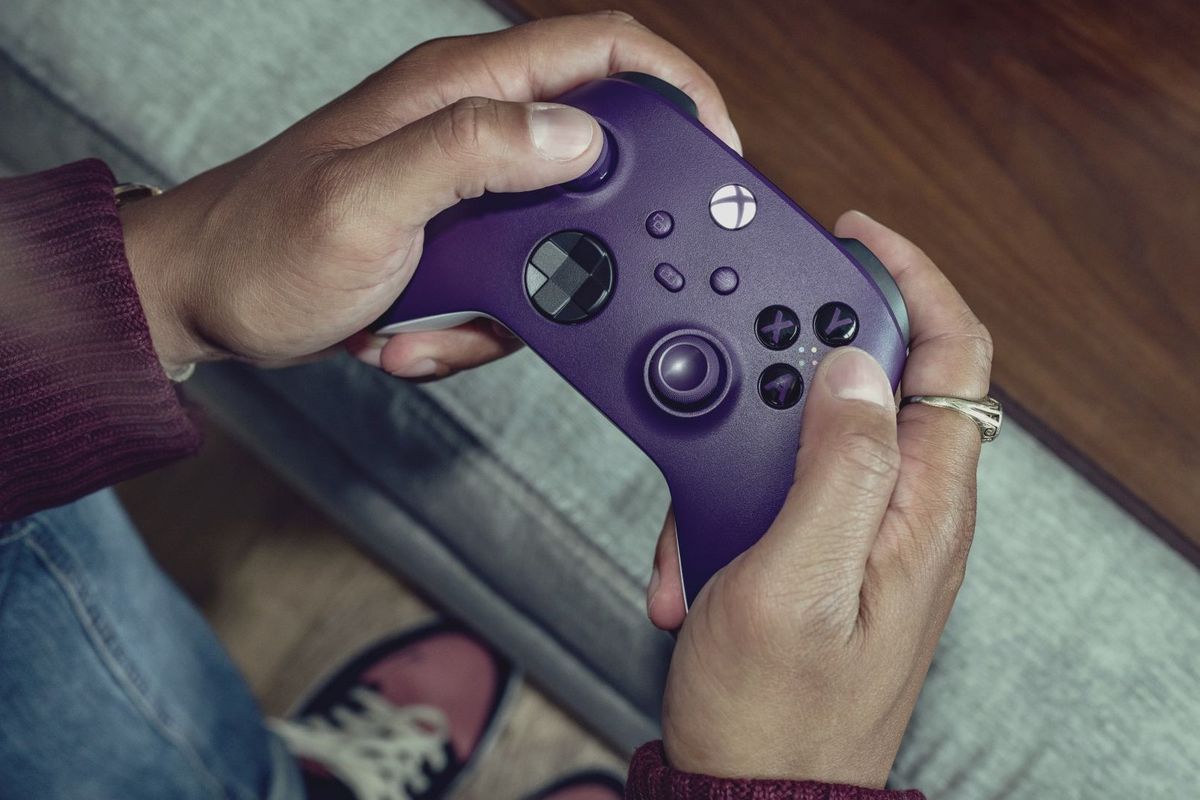 a man holds an astral purple xbox wireless controller 