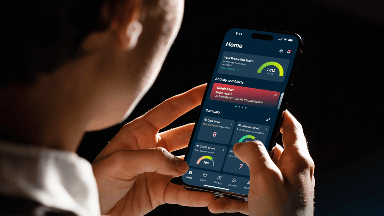 a man holds an iPhone in both hands with ExpressVPN shown on-screen