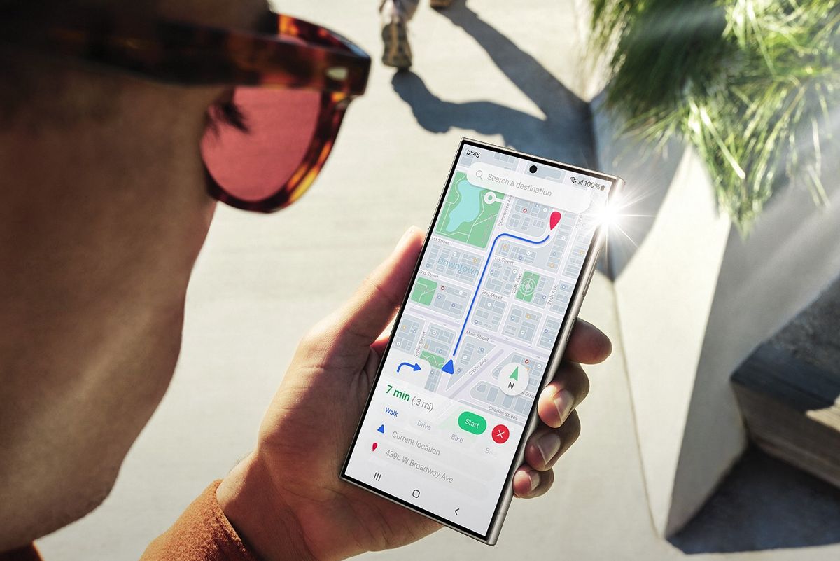 a man holds out a galaxy s24 ultra with light reflecting on the 6.8-inch screen