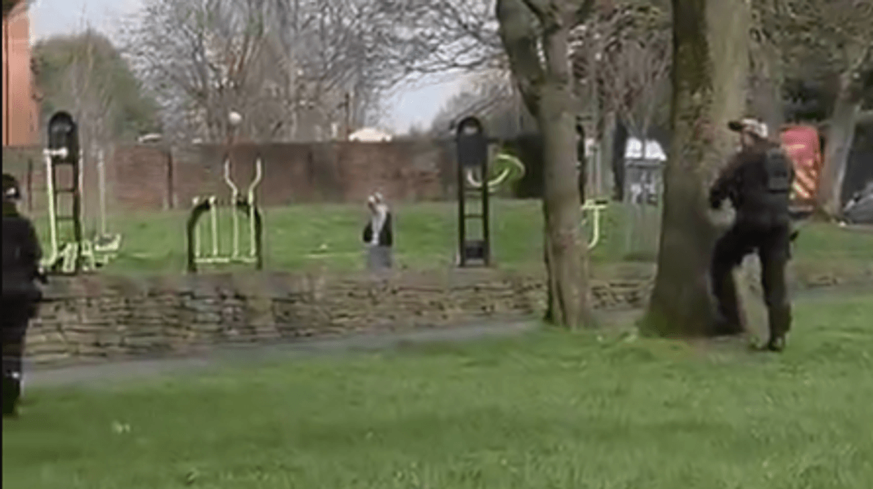 A man in an exercise park surrounded by police