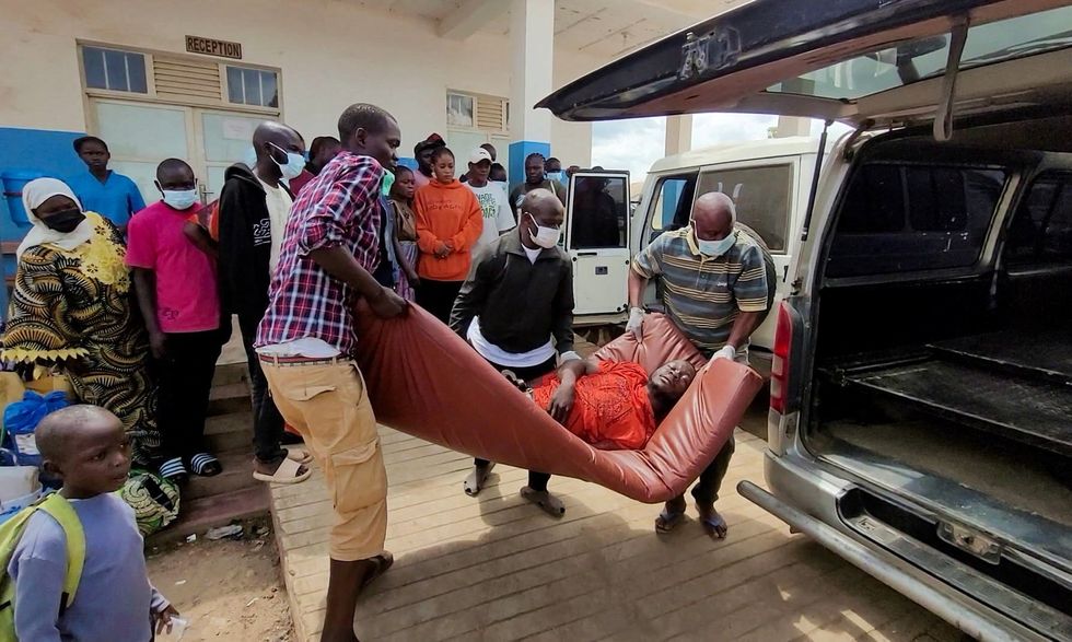 A man is carried from an ambulance as he arrives at hospital in the DRC following confirmation of an Ebola outbreak involving the Bundibugyo strain