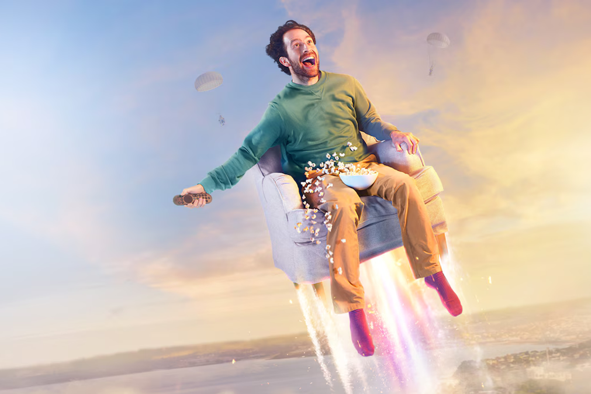 a man is catapulted into the air on a chair with popcorn and a remote control