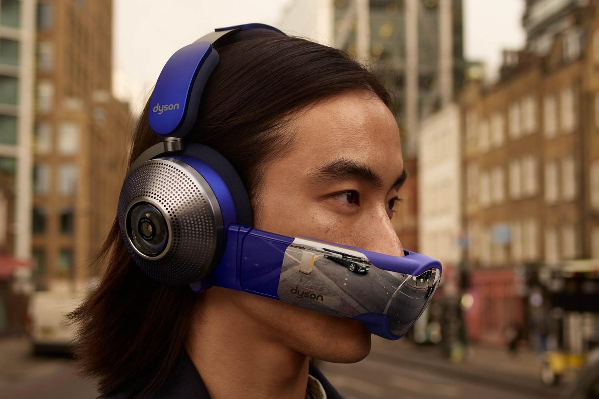a man is pictured in a busy city wearing the dyson zone headset with the detachable air purifying visor