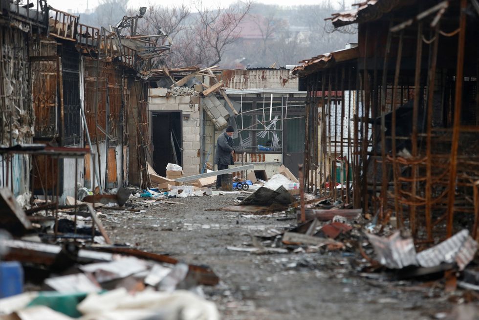 A man is seen amidst the debris of buildings, which were damaged during Ukraine-Russia conflict in the southern port city of Mariupol.