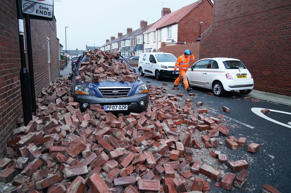 A man makes safe fallen masonry from a property, which has damaged a nearby car, on Gloucester Avenue in Roker, Sunderland
