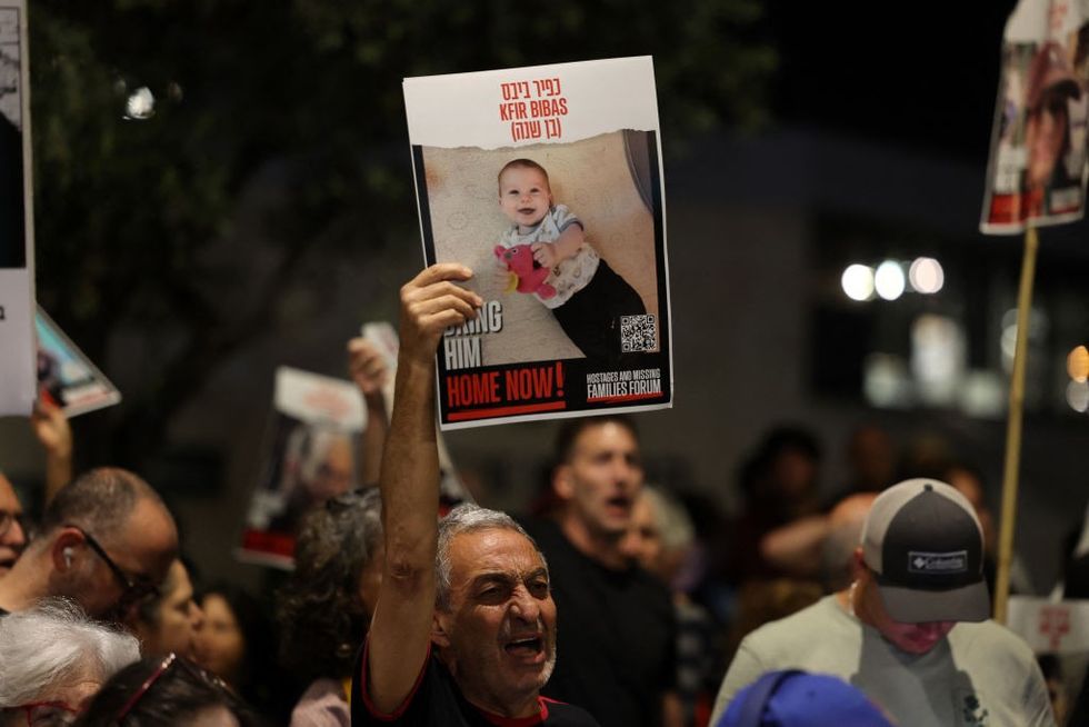A man raises a portrait of Kfir Bibas\u200b