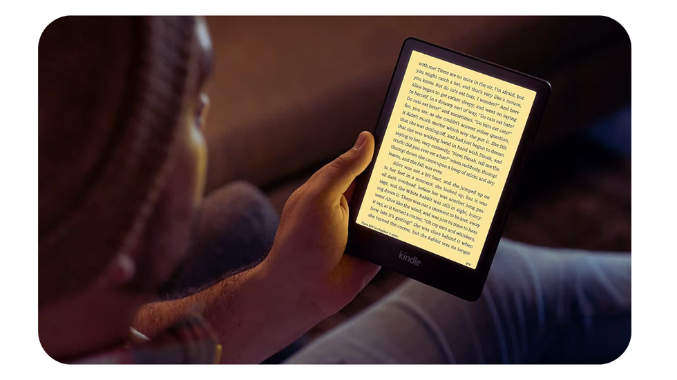 a man reads on the kindle paperwhite at night with the warm backlight illuminated