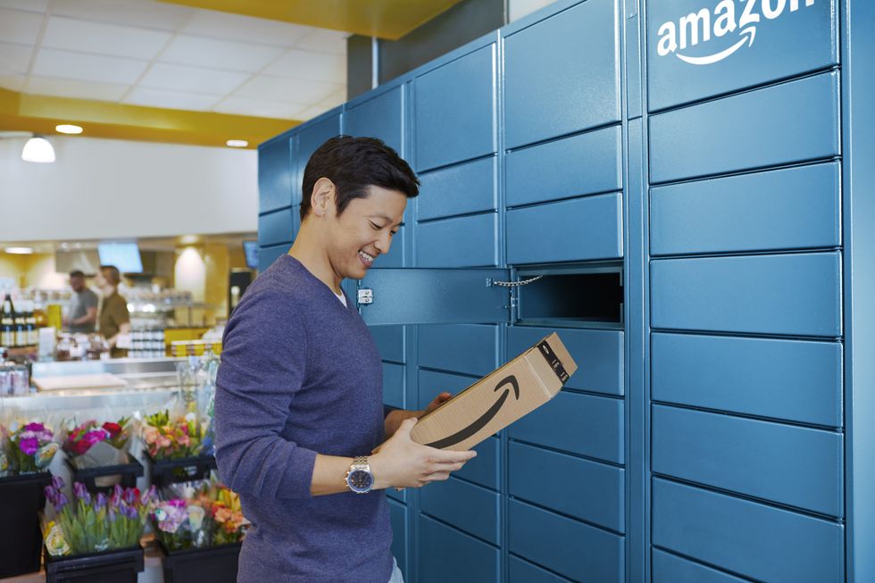 a man removes an amazon branded parcel from an amazon locker