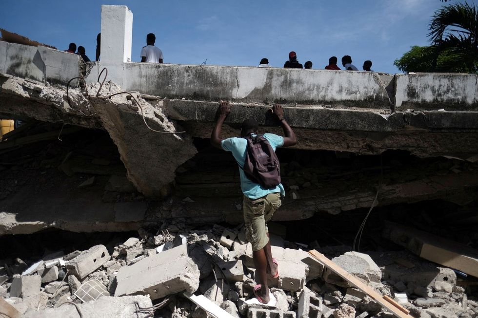 A man searches the site of a collapsed hotel after Saturday's 7.2 magnitude quake, in Les Cayes, Haiti August 16, 2021. REUTERS/Ricardo Arduengo TPX IMAGES OF THE DAY