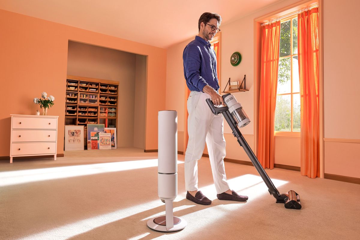 a man stands and uses the cordless samsung bespoke jet cleaner