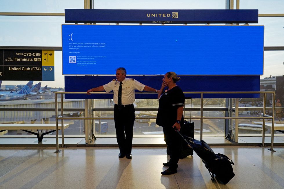 a man stands in front of the BSOD in Newark airport