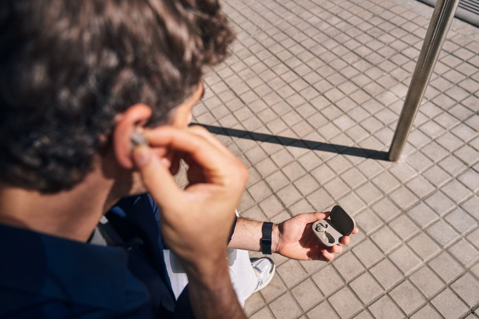 a man takes a Powerbeats Fit out of the case and into his ear