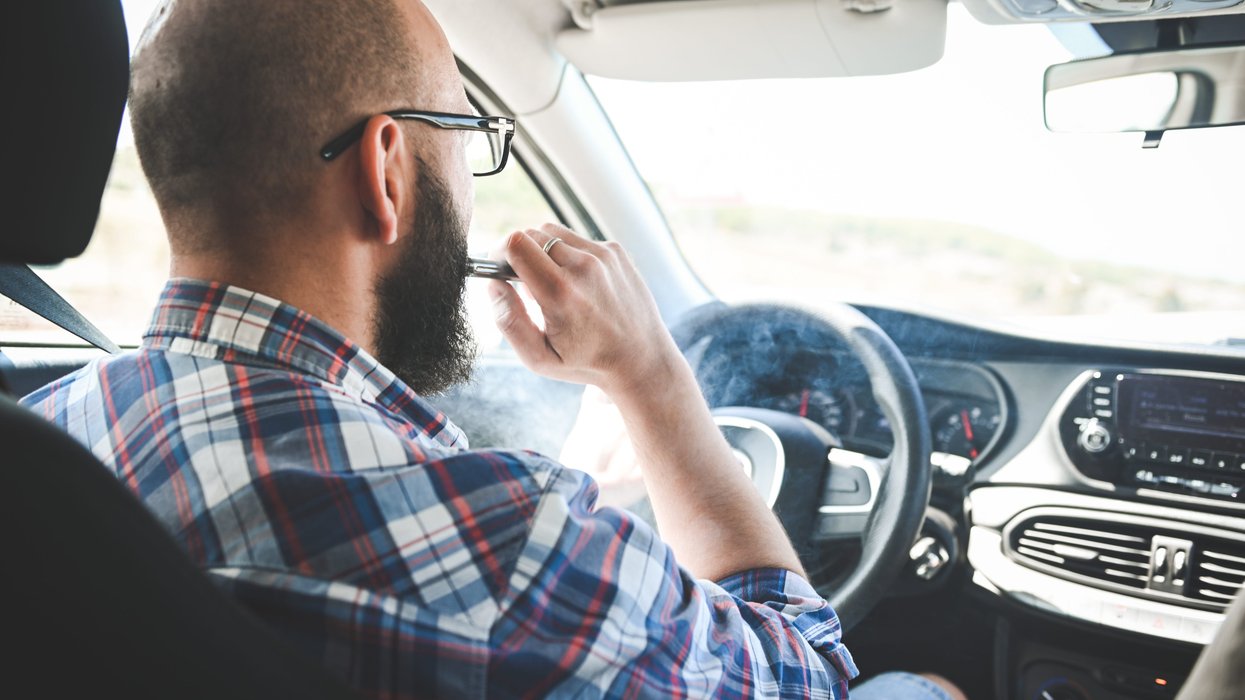 A man vaping in a car