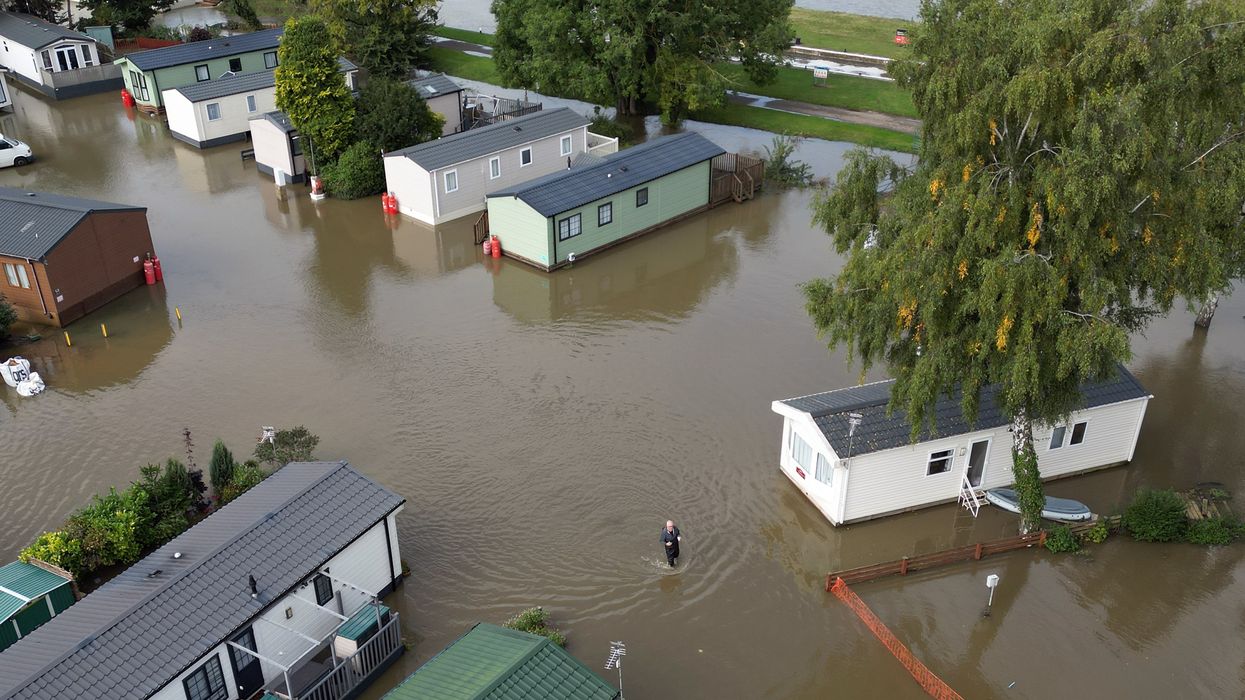 A man wades through floodwater at Cogenhoe Mill Holiday Park in Northamptonshire after the River Nene burst its banks
