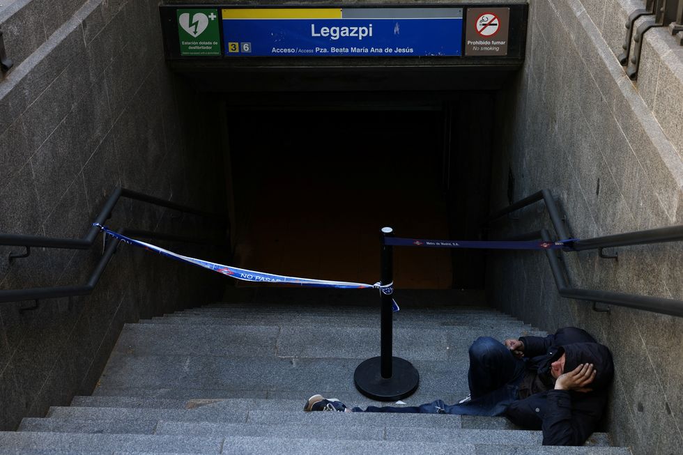 A man waits for the metro station to be opened, during a power outage