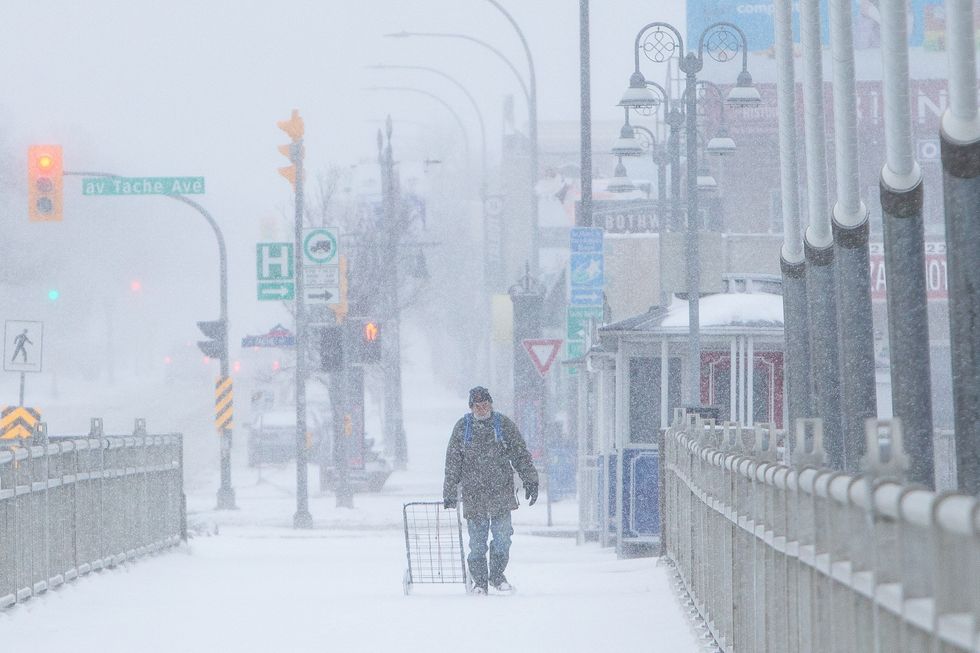 A man walking along a snowy street in Canada