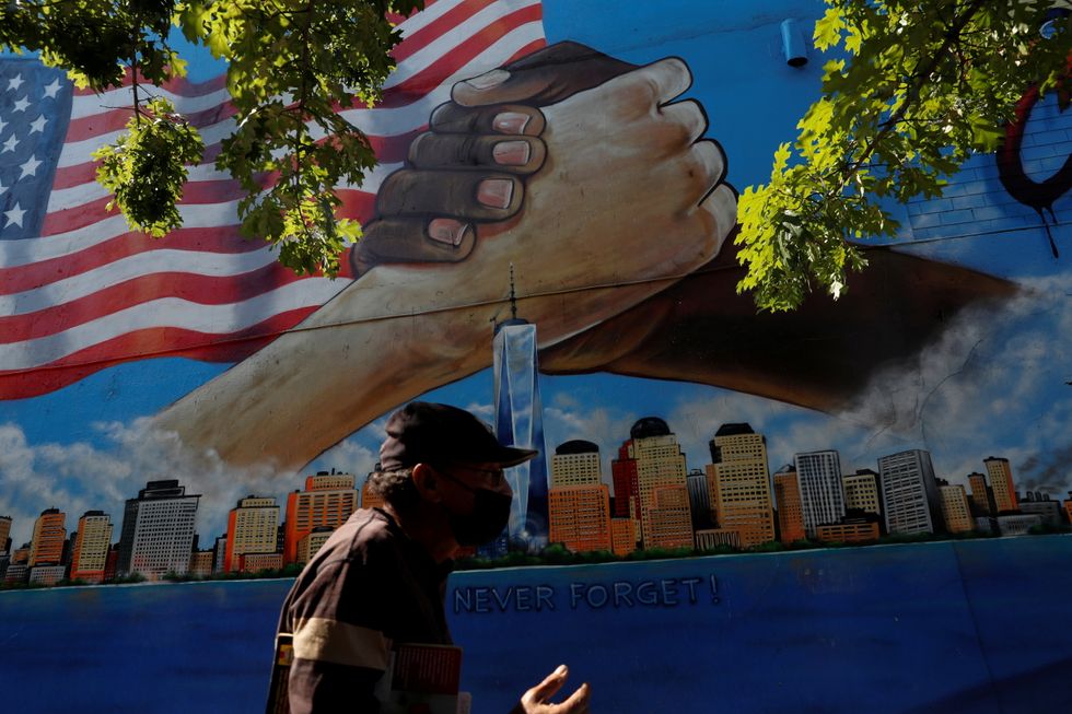 A man walks by a 9/11 memorial mural in the Bronx borough of New York City, U.S.