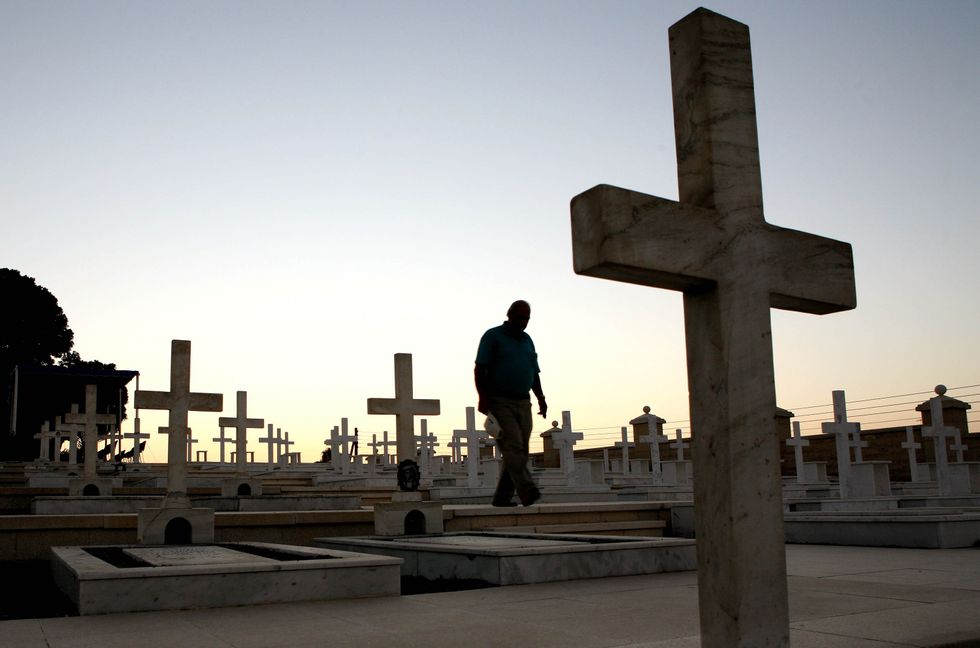 A man walks past graves of Greek and Cypriot soldiers, who were killed during the 1974 Turkish invasion of Cyprus, at the Tymvos Macedonitissas military cemetery in Nicosia