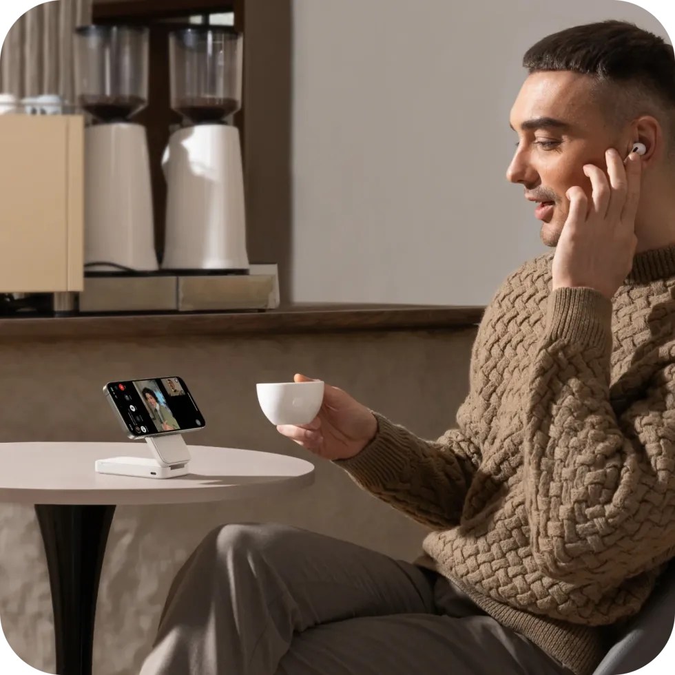 a man watches a show on his iphone while its propped up on an anker external power bank