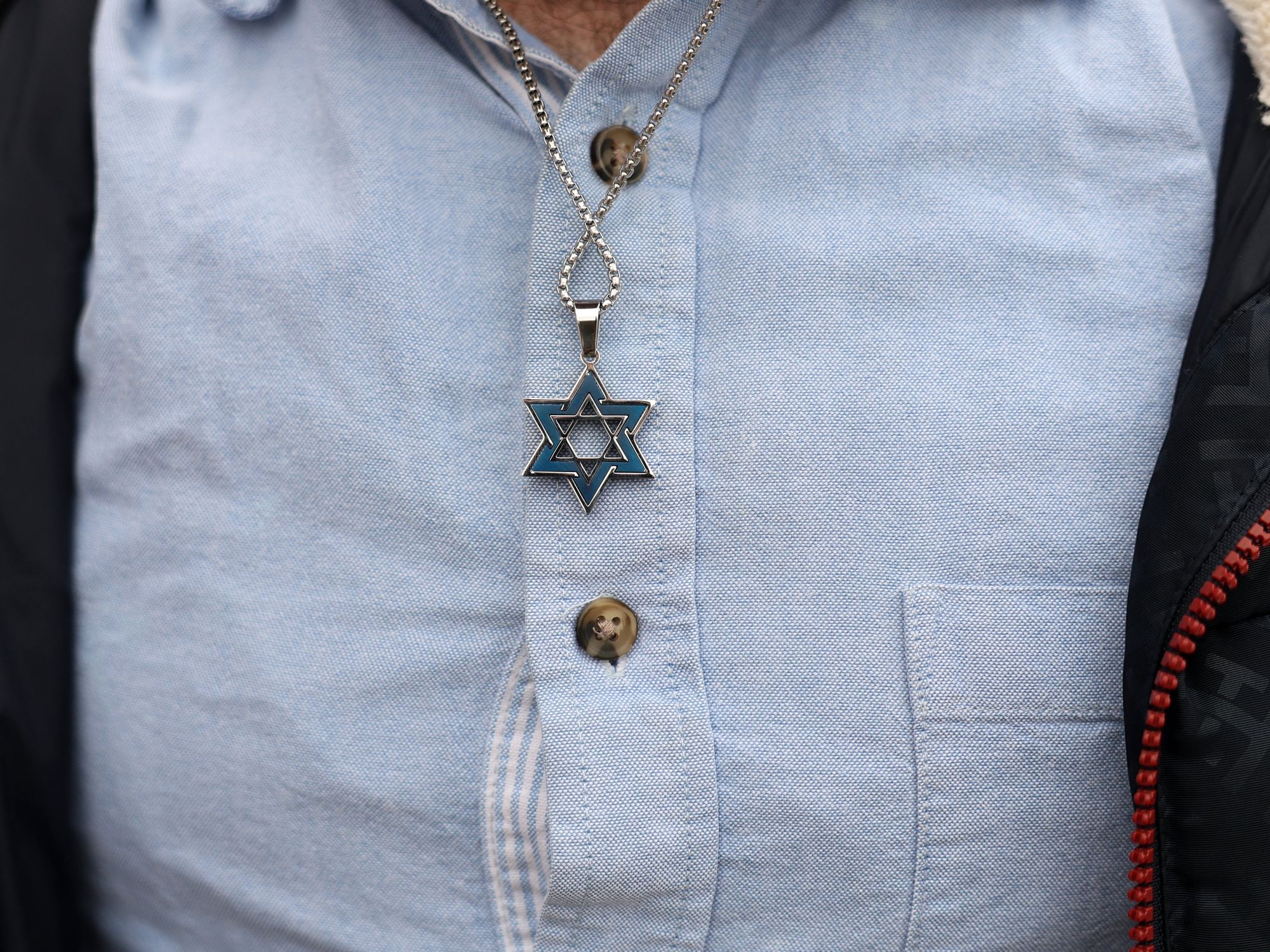 A man wearing a Star of David necklace