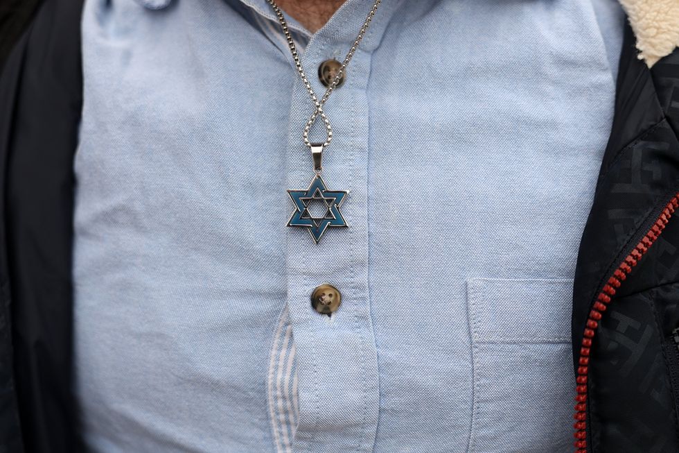 A man wearing a Star of David necklace