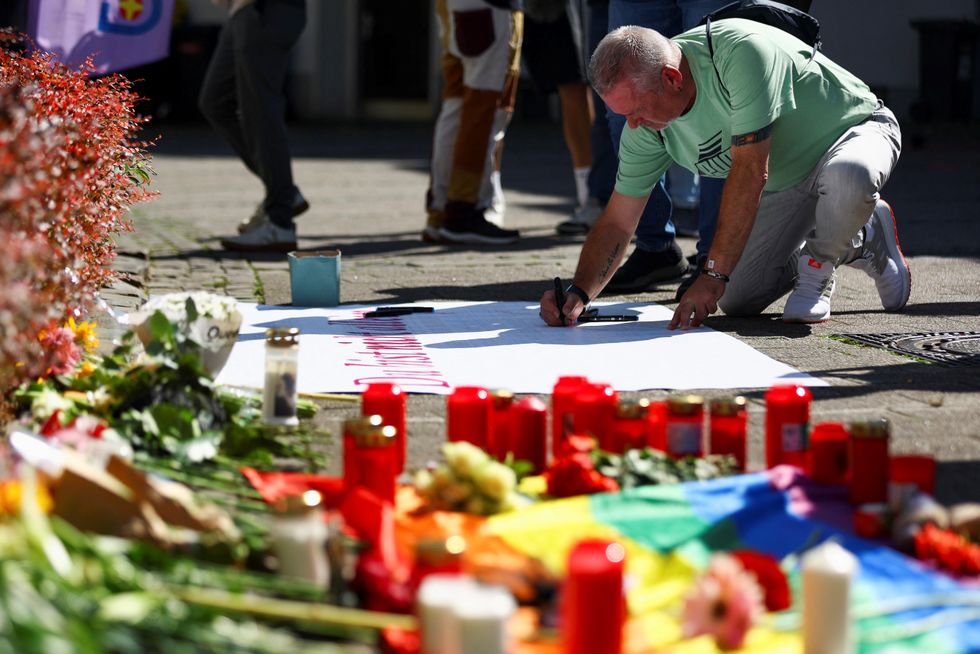 A man writes a message on a placard following the incident