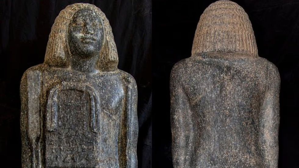 A massive black granite statue of a standing man, measuring 1.17 metres