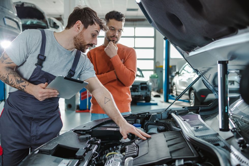 A mechanic explaining vehicle repairs to a driver