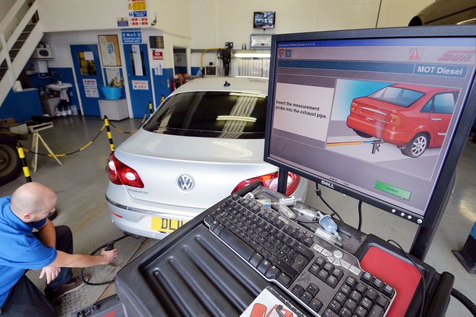 A mechanic inspecting a vehicle's exhaust emissions