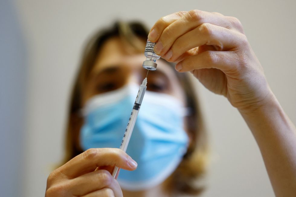 A medical worker prepares a dose of the %22Cominarty%22 Pfizer-Bivalent coronavirus disease (COVID-19) vaccine at a vaccination center in Nice as a new surge in the COVID-19 outbreak starts in France, December 7, 2022. REUTERS/Eric Gaillard